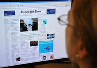 Una persona lee la portada de la edición en internet del periódico New York Times Una persona lee la portada de la edición en internet del periódico New York Times