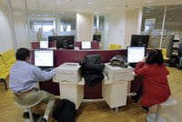 Dos personas trabajando delante de sus ordenadores. Dos personas trabajando delante de sus ordenadores.