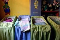 Un bebé duerme en una cuna de un orfanato Un bebé duerme en una cuna de un orfanato